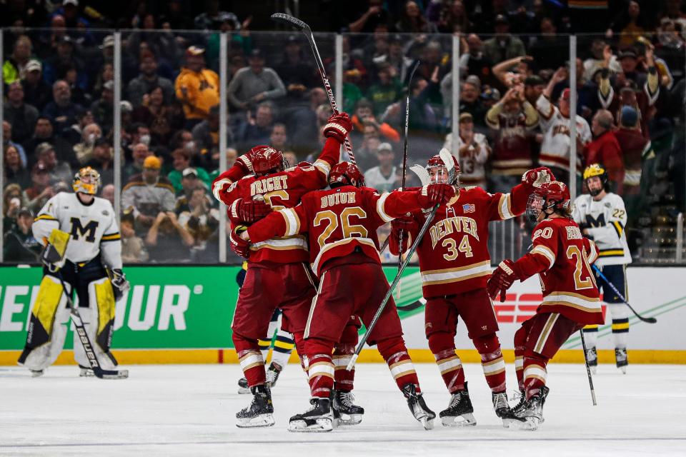 Denver players celebrate a goal against Michigan during the third period of the Frozen Four semifinal at TD Garden in Boston on Thursday, April 7, 2022.