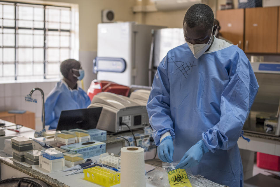 In this photo taken Friday, June 19, 2020, a laboratory specialist secures samples taken from potential coronavirus patients at the country's only laboratory that tests for the coronavirus in Juba, South Sudan. The United Nations says the country's outbreak is growing rapidly, with nearly 1,900 cases, including more than 50 health workers infected, and at the only laboratory in the country that tests for the virus a team of 16 works up to 16-hour days slogging through a backlog of more than 5,000 tests. (AP Photo/Charles Atiki Lomodong)