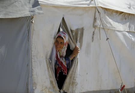A Syrian refugee woman looks out from her tent at Suleymansah refugee camp in Akcakale in Sanliurfa province, Turkey, June 11, 2015. REUTERS/Osman Orsal