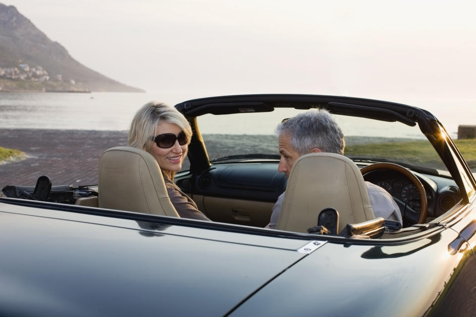 Couple in convertible admiring coastline