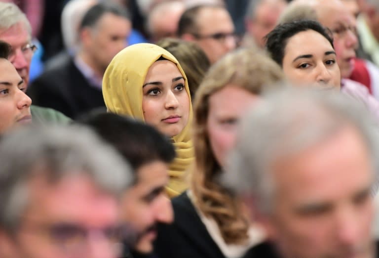 A woman looks on as people take part in a debate on role of Islam in the country at Rotterdam's Essalam mosque on March 10, 2017, ahead of the Dutch parliamentary elections