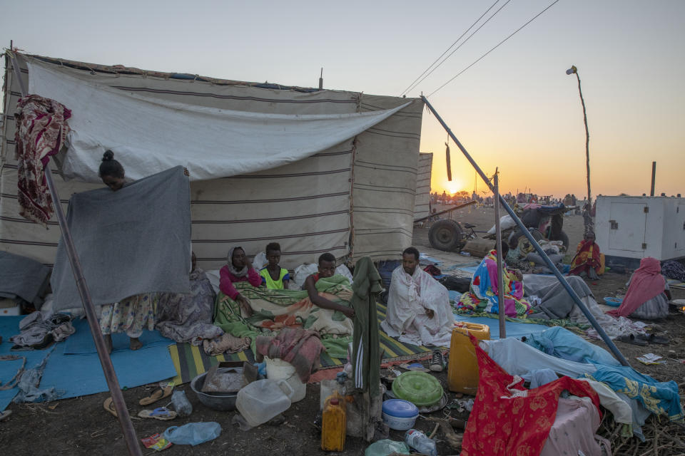 Tigray refugees who fled the conflict in the Ethiopia's Tigray sit up after waking up in the early morning at Hamdeyat Transition Center near the Sudan-Ethiopia border, eastern Sudan, Thursday, Dec. 3, 2020. Ethiopian forces on Thursday blocked people from the country's embattled Tigray region from crossing into Sudan at the busiest crossing point for refugees, Sudanese forces said.(AP Photo/Nariman El-Mofty)