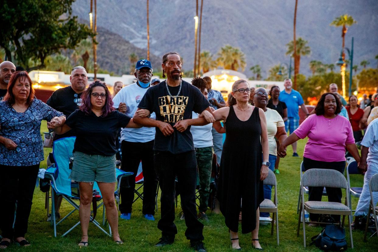 People join arms during a unity rally and prayer vigil for Section 14 Survivors at Frances Stevens Park in Palm Springs, Calif., on Saturday, Sept. 17, 2022. 