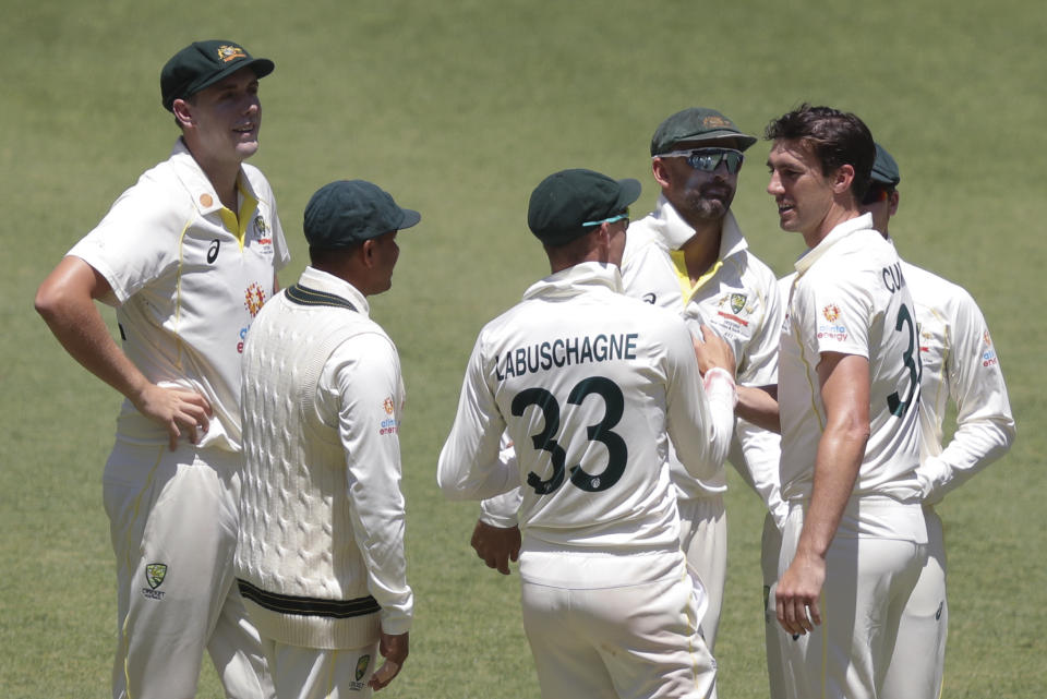 Australia's Pat Cummins, right, is congratulated by teammates after taking the wicket of West Indies' Kragg Brathwaite during play on the third day of the first cricket test between Australia and the West Indies in Perth, Australia, Friday, Dec. 2, 2022. (AP Photo/Gary Day)