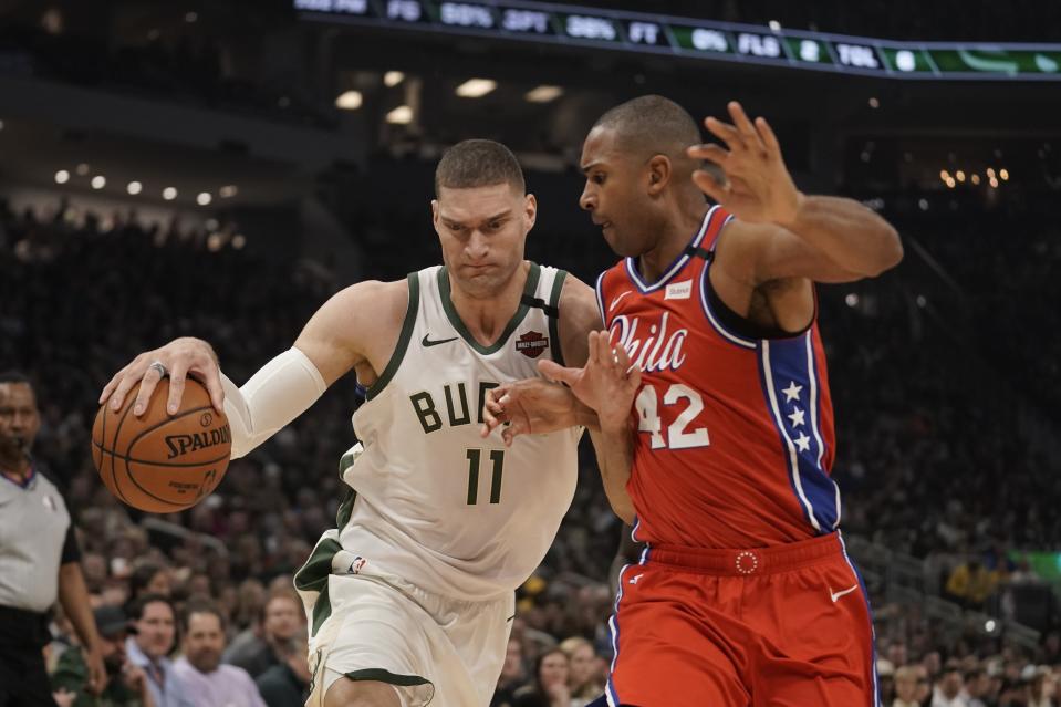 Milwaukee Bucks' Brook Lopez drives past Philadelphia 76ers' Al Horford during the first half of an NBA basketball game Saturday, Feb. 22, 2020, in Milwaukee. (AP Photo/Morry Gash)