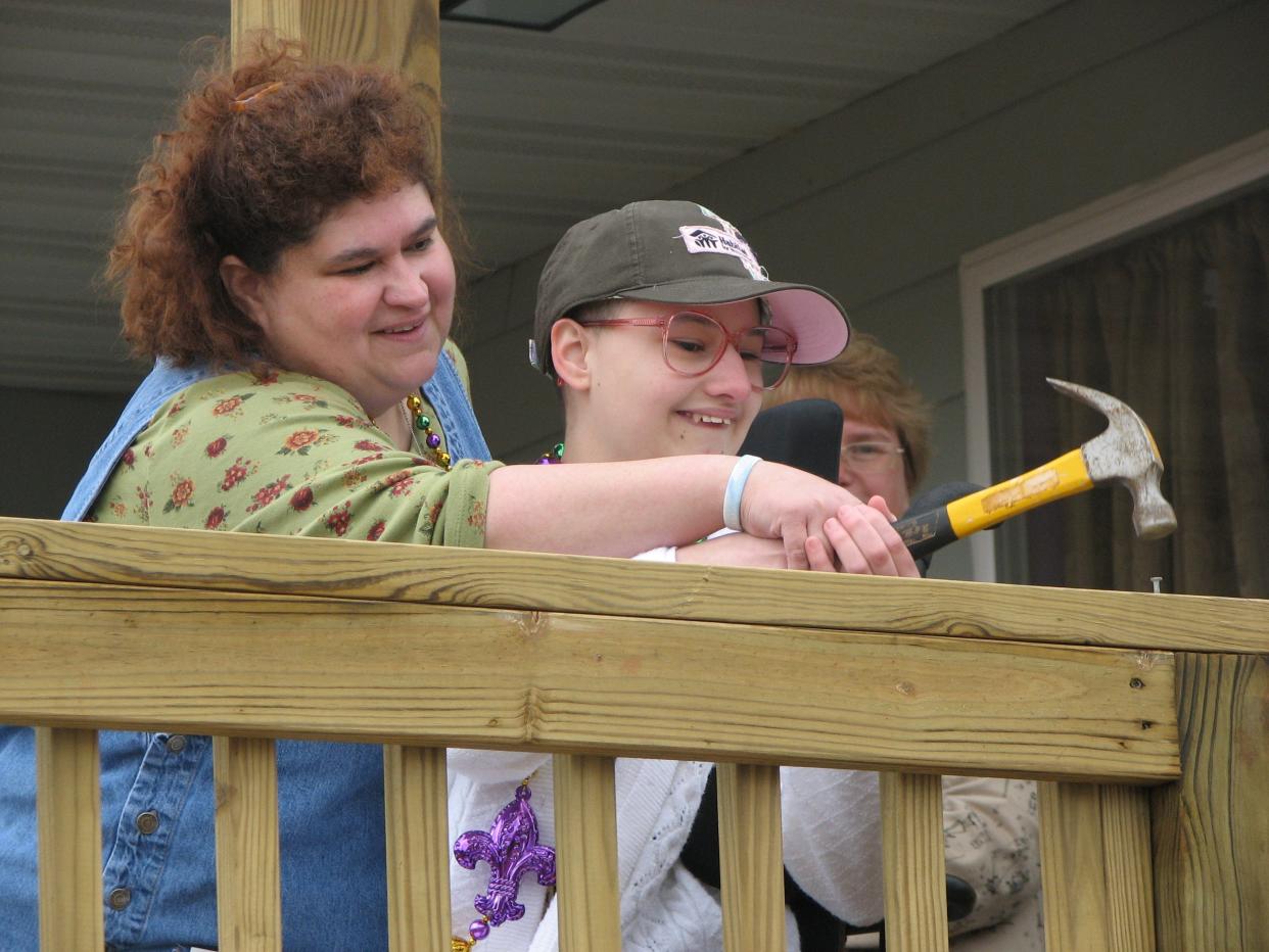 Gypsy Rose Blanchard raises her hammer during the dedication of her family's new home in Springfield, MO alongside her mother, Dee Dee Blanchard, before Dee Dee's death.