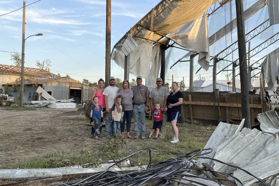 Marianne Eachus and her family pose among the debris at Wellacrest Farms in Mullica Hill, N.J. A tornado passes passed through the area on Wednesday, Sept. 1, 2021.(Marianne Eachus via AP)