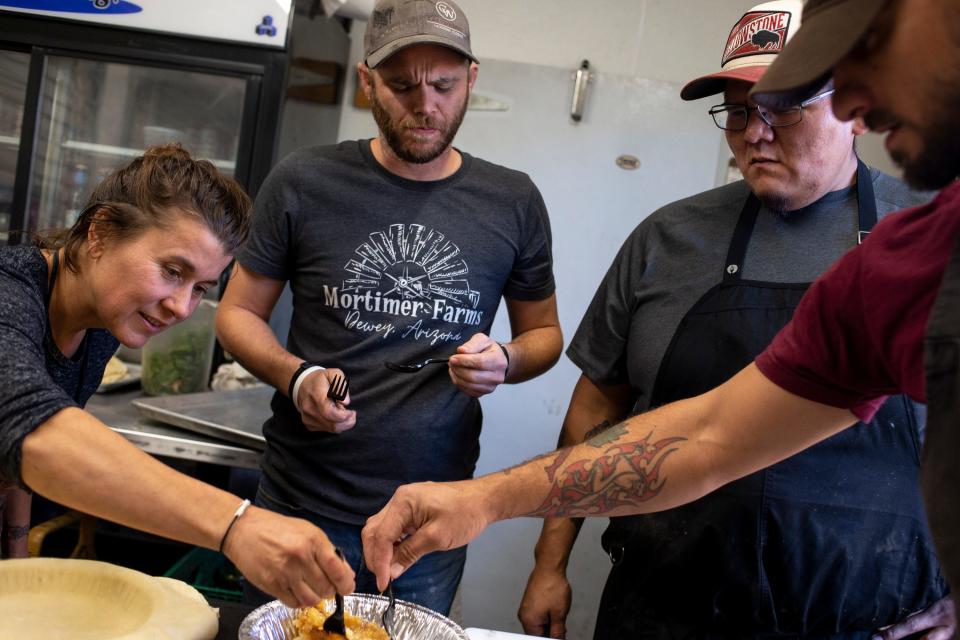 From left: Becky Allen, Brett Vibber, Jaren Bates, and Allen Moore taste an apple pie on Nov. 13, 2020, at Mortimer Farms in Dewey, Arizona. Bates is co-chef with Brett Vibber at WILD, a pop-up dinner concept for which they forage for ingredients and utilize farm-to-table style cooking.