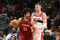 Cleveland Cavaliers center Jarrett Allen (31) dribbles the ball against Washington Wizards center Kristaps Porzingis (6) during the first half of an NBA basketball game, Monday, Feb. 6, 2023, in Washington. (AP Photo/Nick Wass)