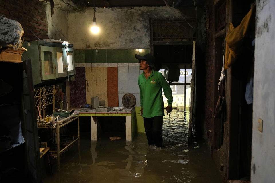 Suwarno visita la casa que abandonó hace dos años al quedar inhabitable por las inundaciones en Mondoliko (Java, Indonesia). Foto del 1ro de agosto del 2022. (AP Photo/Dita Alangkara)