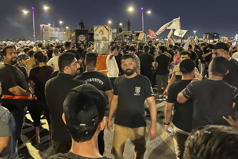 Protesters gather in Baghdad's Tahrir Square, carrying Iraqi flags and images of influential Iraqi Shiite cleric and political leader Muqtada al-Sadr, Saturday, July 22, 2023, following reports of the burning of a Quran carried out by a ultranationalist group in front of the Iraqi Embassy in Copenhagen. Protesters attempted to cross the Jumhuriya bridge leading to the Green Zone, where the Danish embassy is, but were pushed back by security forces. (AP Photo/Ali Jabar)