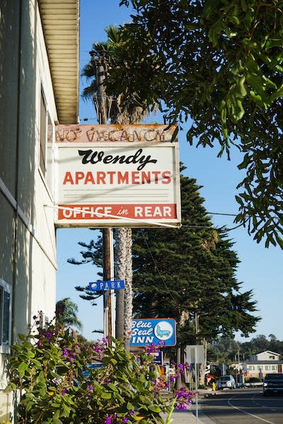 A worn-out sign street advertising apartments for rent.