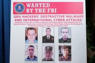 A poster showing six wanted Russian military intelligent officers is displayed before a news conference at the Department of Justice, in Washington