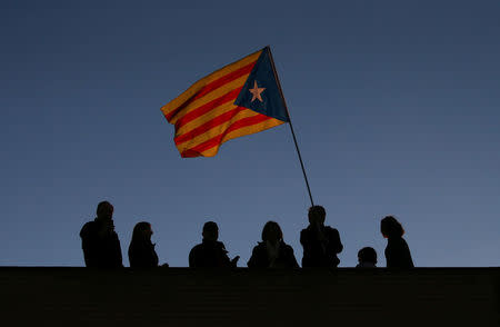 A man waves an "Estelada" flag on top of a building, during a demonstration called by pro-independence associations asking for the release of jailed Catalan activists and leaders in Barcelona, Spain, November 11, 2017. REUTERS/Albert Gea