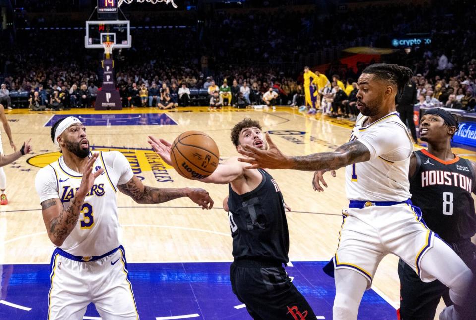 Lakers guard D'Angelo Russell passes to teammate Anthony Davis around the defense of Rockets center Alperen Sengun.