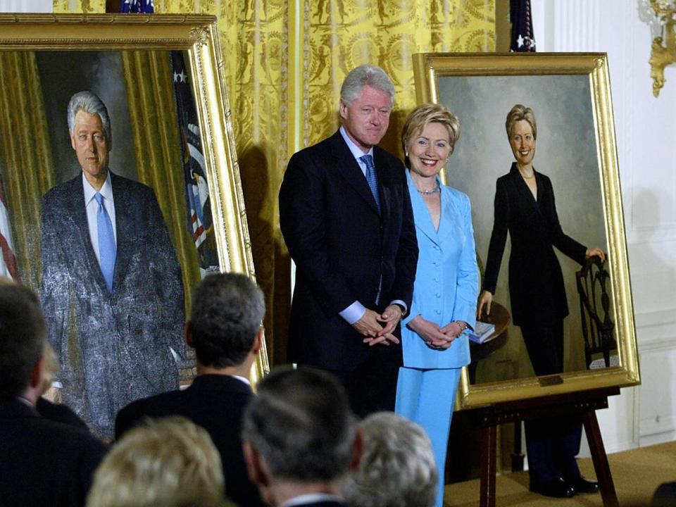 President Bill Clinton and First Lady Hillary Clinton stand in between their newly unveiled official White House portraits.