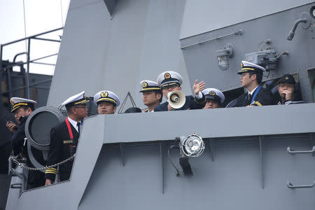 A Chinese navy personnel guides on the Japan Maritime Self-Defense Force destroyer JS Suzutsuki (DD 117) as it arrives at Qingdao Port for the 70th anniversary celebrations of the founding of the Chinese People's Liberation Army Navy (PLAN), in Qingdao, China April 21, 2019. REUTERS/Jason Lee
