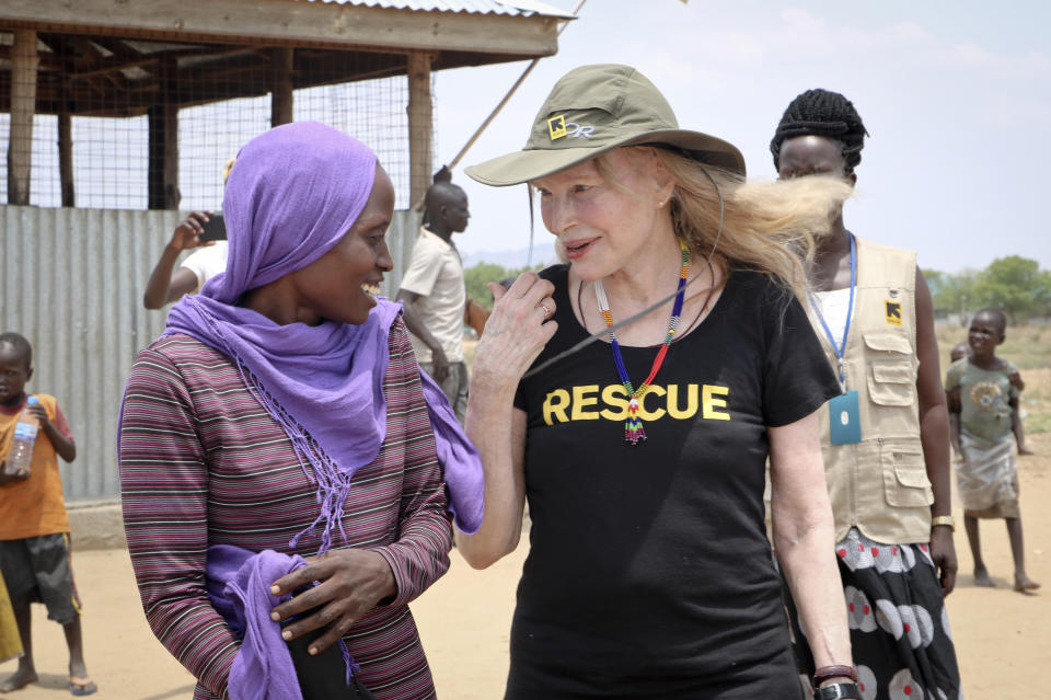 In this photo taken Tuesday, April 2, 2019, human rights activist Mia Farrow laughs with staff from the International Rescue Committee while visiting an internally displaced person's camp in the capital Juba, South Sudan. Human rights activist Mia Farrow spoke to The Associated Press as she visited South Sudan again in her new role as envoy for the International Rescue Committee, helping the aid group to promote a global initiative to change the way humanitarian organizations approach malnutrition. (AP Photo/Sam Mednick)