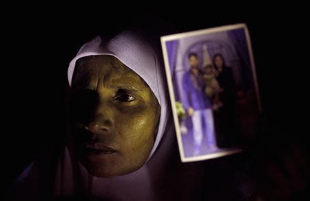 A Muslim woman holds up an image of her family members who disappeared during the civil war with the Liberation Tigers of Tamil Eelam (LTTE) at a vigil to commemorate the international day of the disappeared in Colombo August 30, 2013. REUTERS/Dinuka Liyanawatte