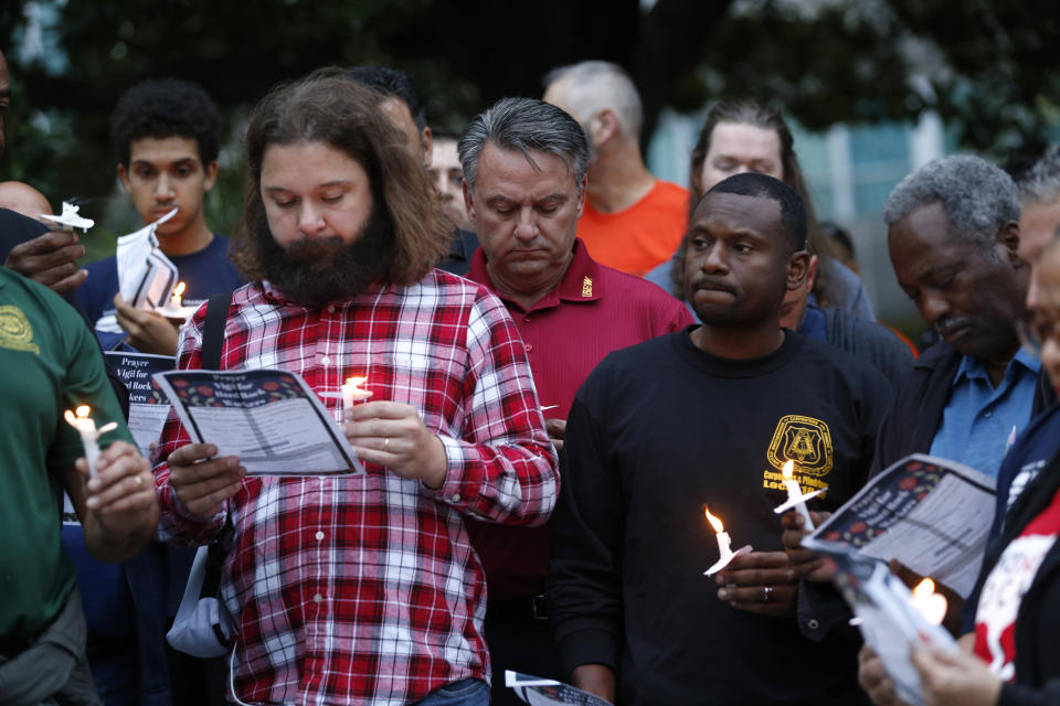 People hold candles during a candlelight vigil outside city hall for deceased and injured workers from the Hard Rock Hotel construction collapse Sat., Oct. 12, in New Orleans, on Thursday, Oct. 17, 2019. The vigil was organized by various area labor groups. (AP Photo/Gerald Herbert)