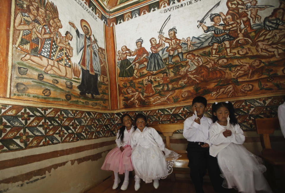 Children wait te be baptized inside the Sistine Chapel of Los Andes in Curahuara de Carangas, Oruro department, 260 km. (160 miles) south from La Paz, Bolivia, Saturday, Dec. 8, 2012. The colonial-era house of worship known in Bolivia as the Sistine Chapel of the Andes was filled with flowers over the weekend for those celebrating two weddings and seven baptisms on the wind swept mountain plateau.(AP Photo/Juan Karita)