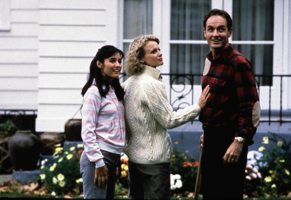 A teenager, her mother and stepfather are all smiles in front of their idyllic home