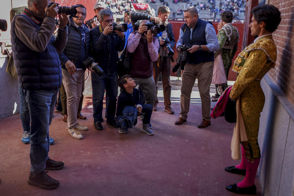 Photographers take pictures of Spanish bullfighter Alvaro Alarcon, right, before a bullfight with young bulls at Las Ventas bullring in Madrid, Spain, Sunday, March 26, 2023. The death of Spanish bullfighting has been declared many times, but the number of bullfights in the country is at its highest level in seven years, and the young are the most consistent presence as older groups of spectators drop away. (AP Photo/Manu Fernandez)