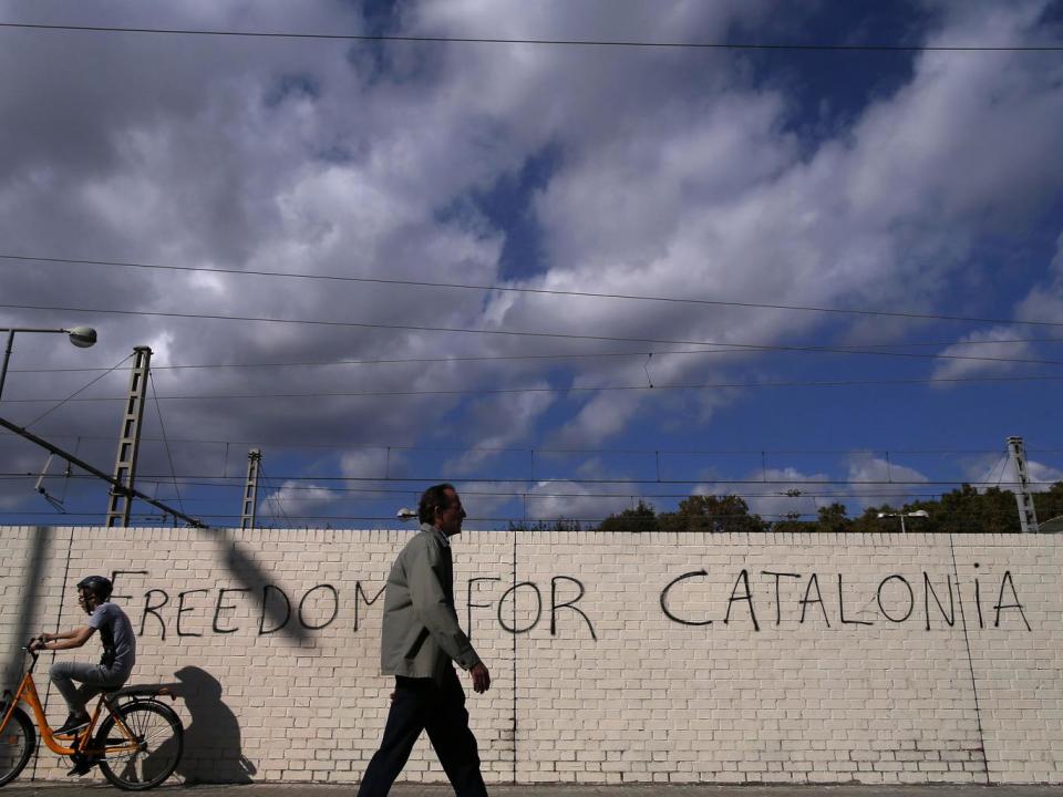 People pass in front of graffiti reading