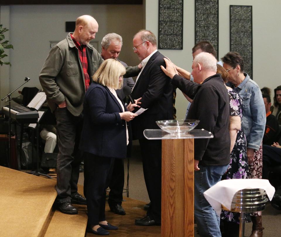 Pastor Brian Malison who is retiring after 35 years as pastor of Christ Lutheran Church, is shown during service with church members laying hands on him in prayer in Visalia, Calif., Sunday, Feb. 26, 2023.