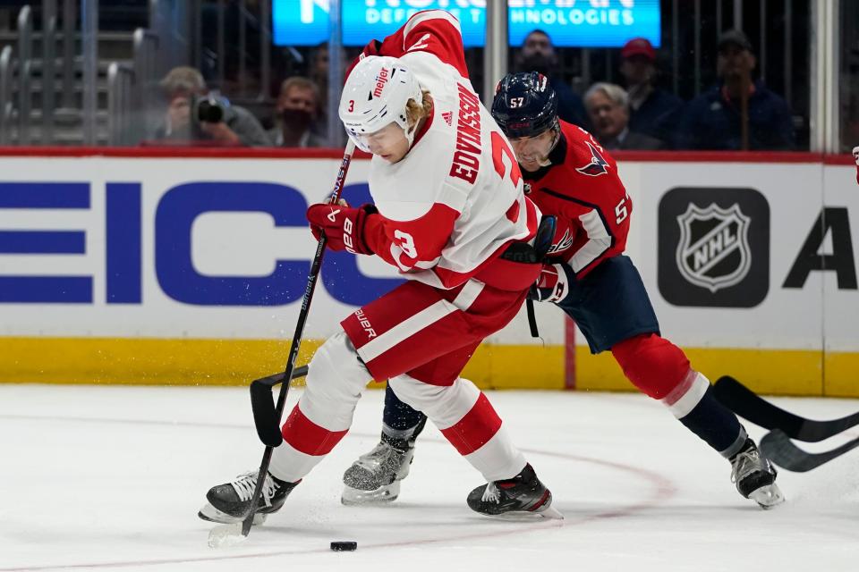 Detroit Red Wings defenseman Simon Edvinsson (3) and Washington Capitals defenseman Trevor van Riemsdyk (57) compete for the puck during the first period of a preseason NHL hockey game Wednesday, Oct.  5, 2022, in Washington.