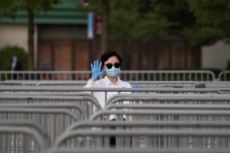 A staff member wearing face mask gestures at Shanghai Disney Resort as the Shanghai Disneyland theme park reopens following a shutdown due to the coronavirus disease (COVID-19) outbreak, in Shanghai