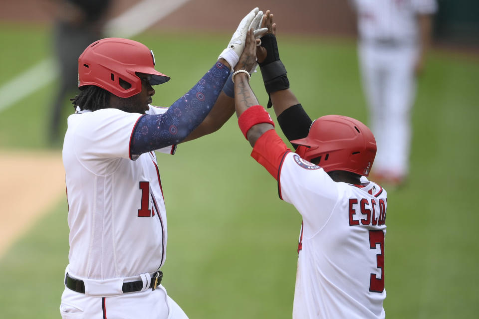 Washington Nationals' Josh Bell, left, celebrates his two-run home run with Alcides Escobar, right, during the first inning of a baseball game against the New York Mets, Sunday, Sept. 5, 2021, in Washington. (AP Photo/Nick Wass)