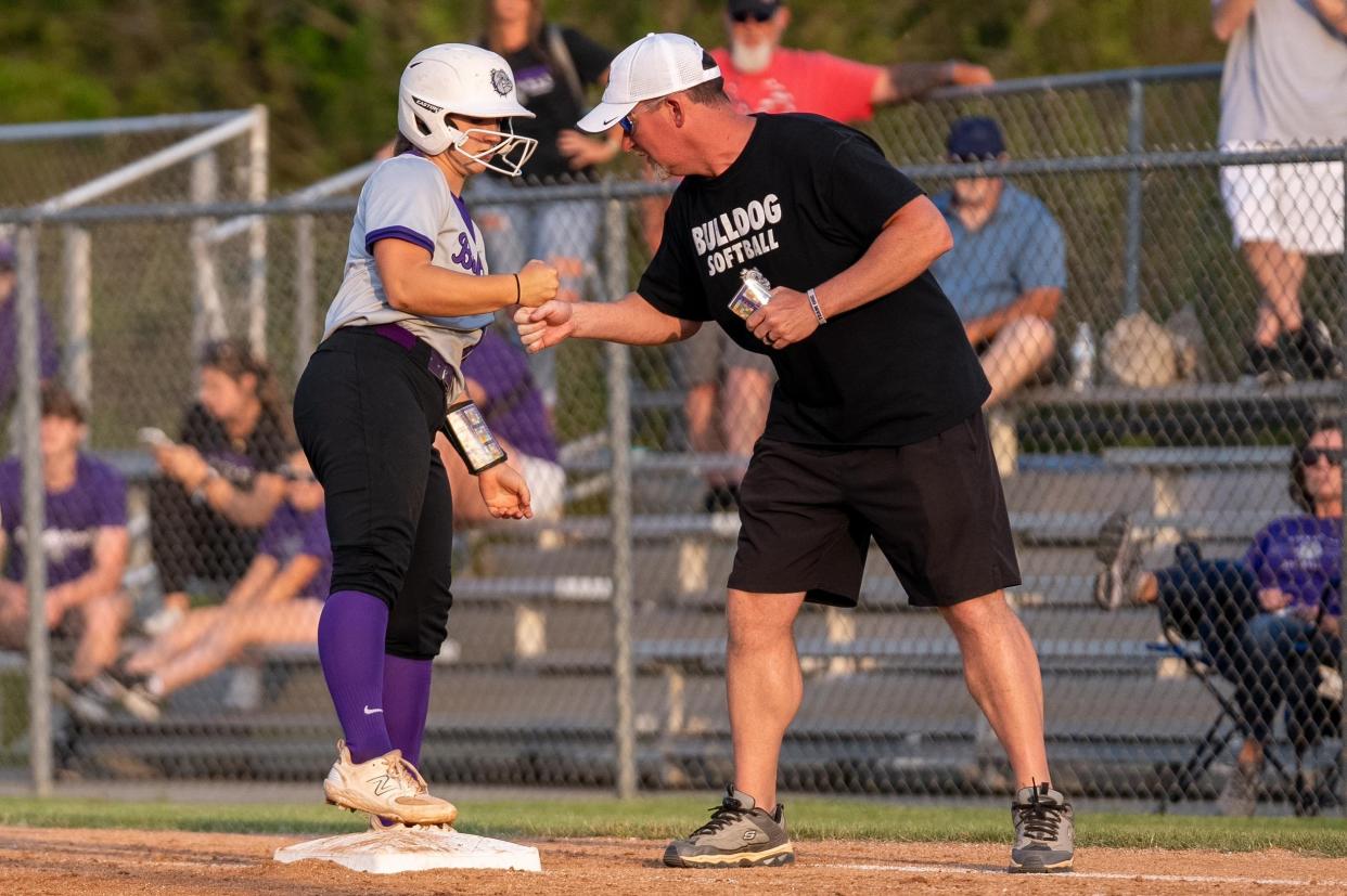 Bulldogs catcher and third baseman and freshman Ava-Grace Pogue celebrates with her assistant coach Tim Pogue after getting on base during their game against the Avon Orioles on Wednesday, May 24, 2023, in Indianapolis during the softball sectional finals at Avon High School. The Orioles went on to win the game.