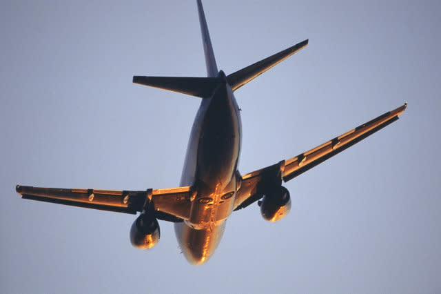 BMI British Midland International Boeing 737-500 climbing enroute at dusk with sun glinting off the fuselage and wings