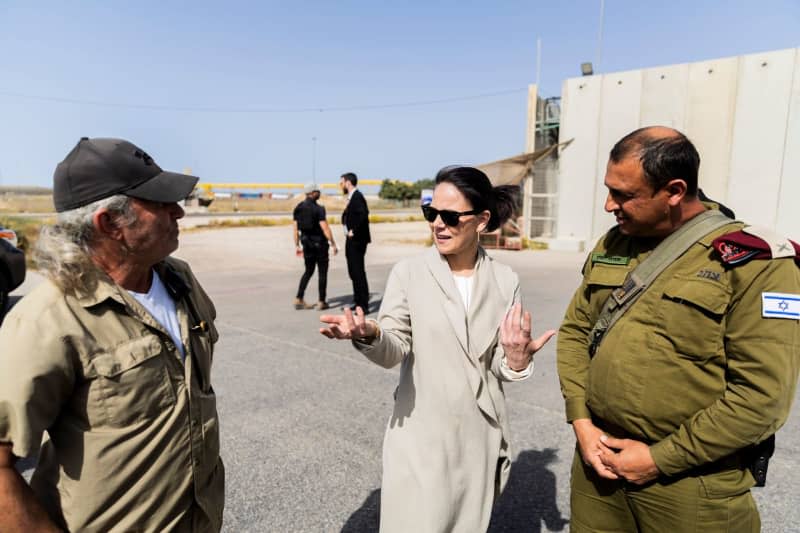 German Foreign Minister Annalena Baerbock (C) talks to Director of the Kerem Shalom border crossing Ami Shaked (L) and a representative of the COGAT unit of the Israeli Ministry of Defense during a visit to the Kerem Shalom border crossing to the Gaza Strip on the Israeli side. Christoph Soeder/dpa-Pool/dpa