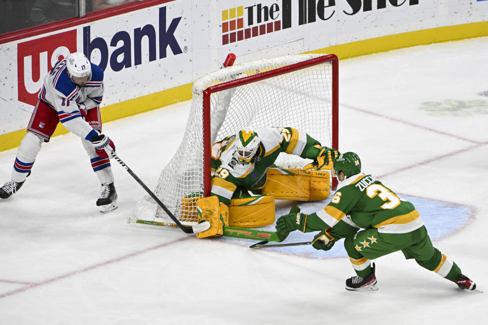 Minnesota Wild goalie Marc-Andre Fleury, center, makes a save on a shot by New York Rangers right wing Blake Wheeler, left, as Wild right wing Mats Zuccarello, right, skates past during the third period of an NHL hockey game Saturday, Nov. 4, 2023, in St. Paul, Minn. (AP Photo/Craig Lassig)