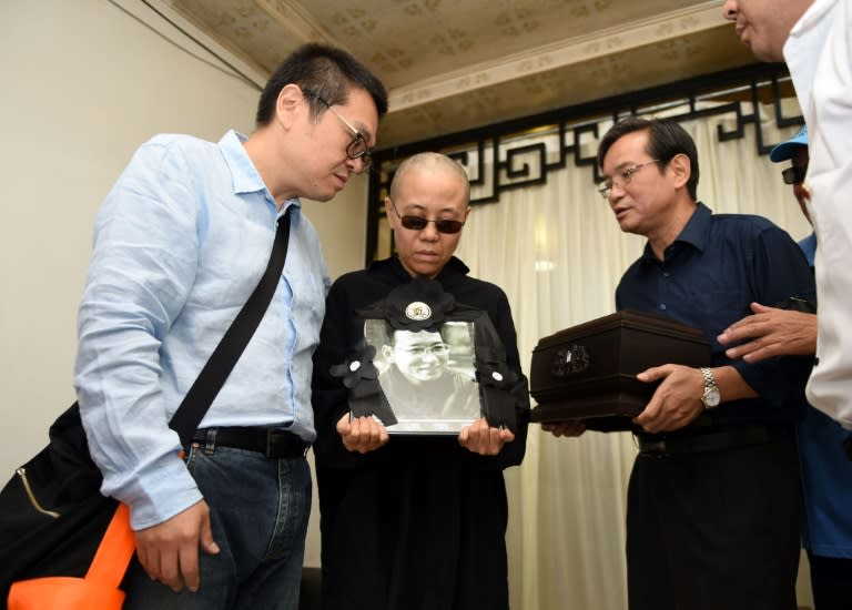 Photo provided by the Shenyang Municipal Information Office shows late Nobel laureate Liu Xiaobo's wife Liu Xia (C) and his brother, Liu Xiaoguang (L), holding a portrait of Liu Xiaobo at a funeral parlour in the city of Shenyang on July 15, 2017