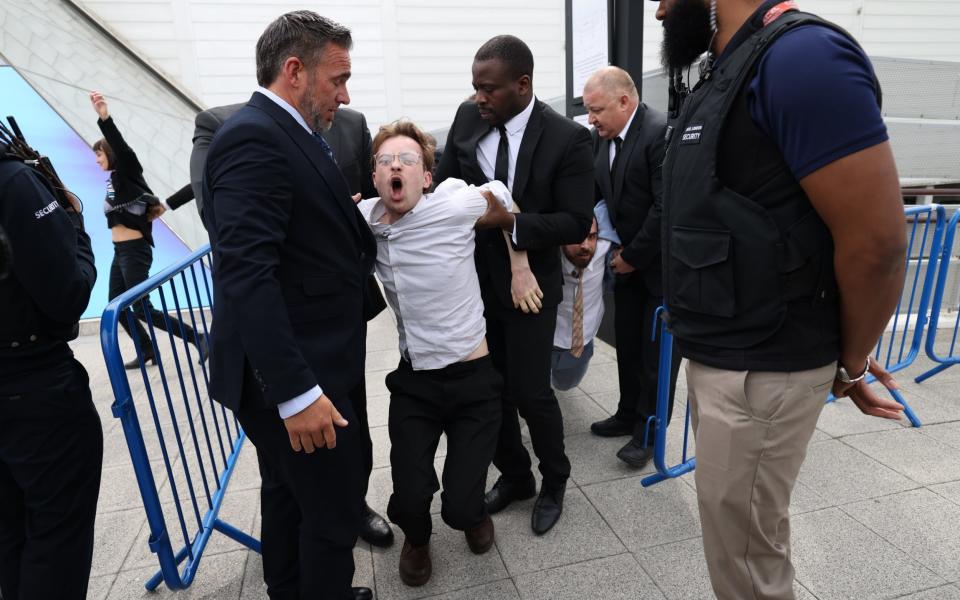 A climate protester is removed from the Shell AGM - Belinda Jiao