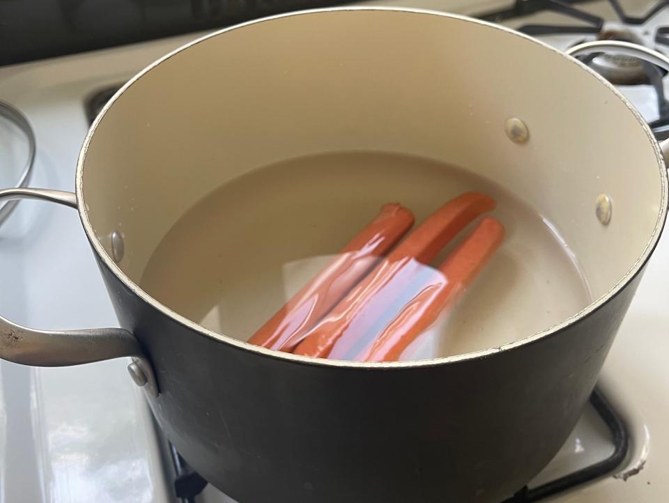 I placed three hot dogs in my pot and set it to boil.