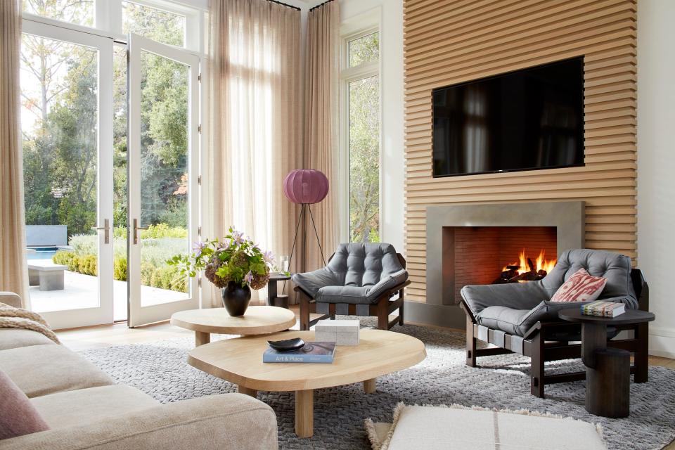 In the Atherton home, the abundant fireplaces provide another level of coziness. Two Lawson-Fenning Ojai lounge chairs and a Poltrona Frau Let It Be sofa, upholstered with Great Plains Lionheart fabric, surround two Stahl + Band L Series tables. The Moroccan wool rug by Marc Phillips and A+R Store Knit-Wit floor lamp lend another dose of texture and color.