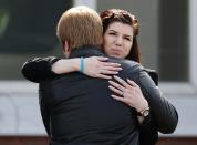 People hug after the funeral of Jordan Segura in Calgary, Alberta April 21, 2014. Matthew de Grood has been charged with killing Segura and four of his friends at a house party last week in Calgary's worst mass murder in the history of the city, according to local media reports. REUTERS/Todd Korol (CANADA - Tags: CRIME LAW OBITUARY)