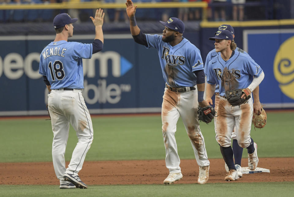 Tampa Bay Rays' Joey Wendle (18), Manuel Margot, center, and Taylor Walls line up after a win over the Baltimore Orioles during a baseball game Sunday, June 13, 2021, in St. Petersburg, Fla. (AP Photo/Steve Nesius)