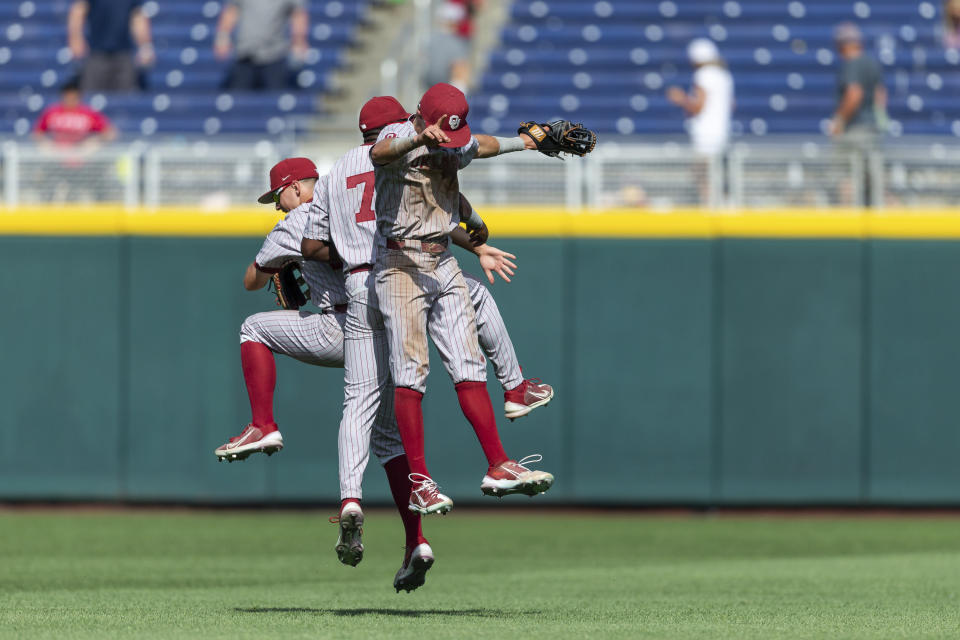 Oklahoma outfielders Tanner Tredaway, left, Kendall Pettis (7) and John Spikerman celebrate the team's win over Texas A&M during an NCAA College World Series baseball game Friday, June 17, 2022, in Omaha, Neb. (AP Photo/John Peterson)