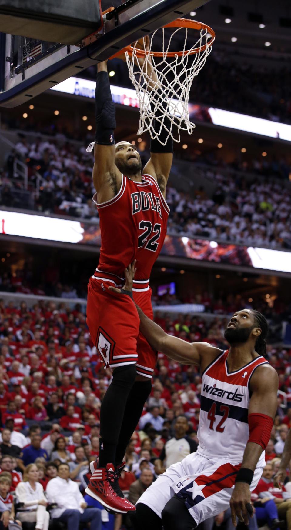 Chicago Bulls forward Taj Gibson (22) dunks in front of Washington Wizards forward Nene (42), from Brazil, in the first half of Game 3 of an opening-round NBA basketball playoff series on Friday, April 25, 2014, in Washington. (AP Photo/Alex Brandon)