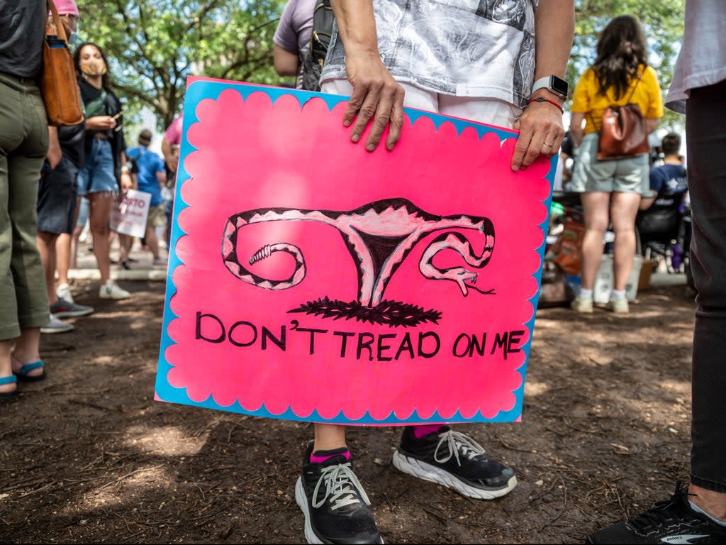 A protester holds a sign before a protest outside the Texas state capitol on 29 May 2021 in Austin, Texas (Getty Images)