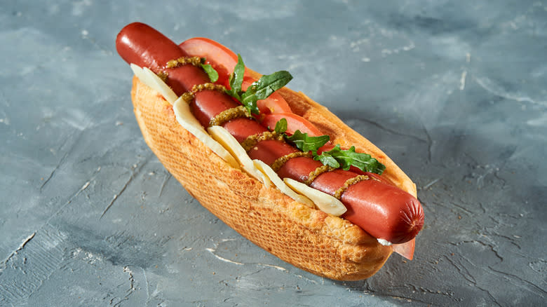 Hot dog drizzled with pesto