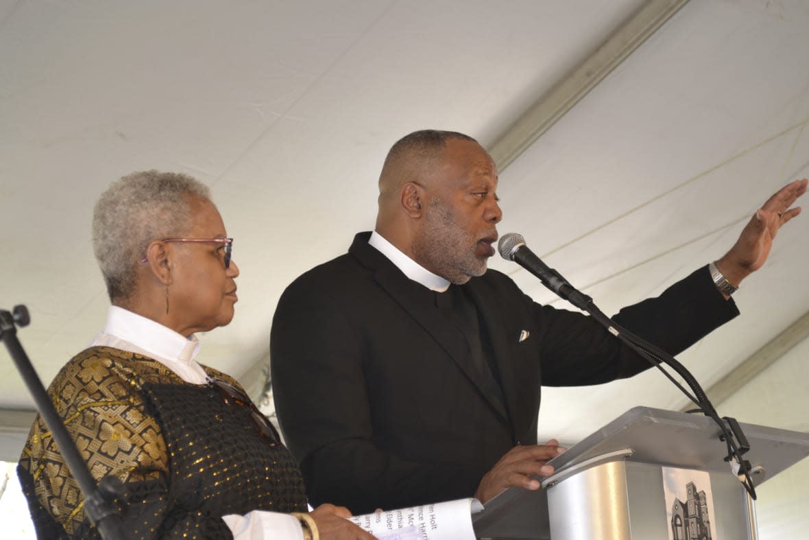 The Rev. Prudence Harris, left, an associate pastor of Bethel AME Church in Pittsburgh, listens as the Rev. Dale Snyder, Bethel’s pastor, speaks at a news conference Friday, April 14, 2023, announcing an agreement with the Pittsburgh Penguins. The NHL hockey club will provide the church a 1.5-acre parcel to the church for redevelopment. The agreement with the Penguins, which holds development rights to a wider area, is seen as “restorative justice” for the church. Harris recalls watching its previous sanctuary being demolished in the 1950s when a large section of a historically Black neighborhood was razed in an urban redevelopment project. (AP Photo/Peter Smith)