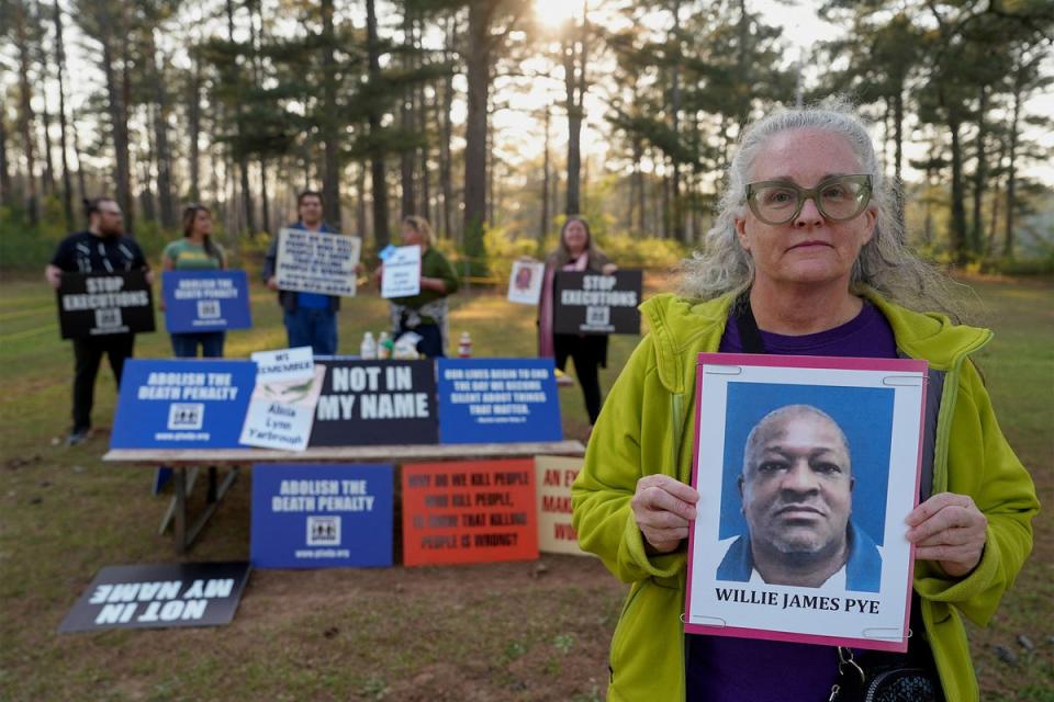 Cathy Harmon-Christian, the executive director of ‘Georgians for Alternatives to the Death Penalty’, holds a photo of Willie James Pye outside the penitentiary where he was executed (Reuters)
