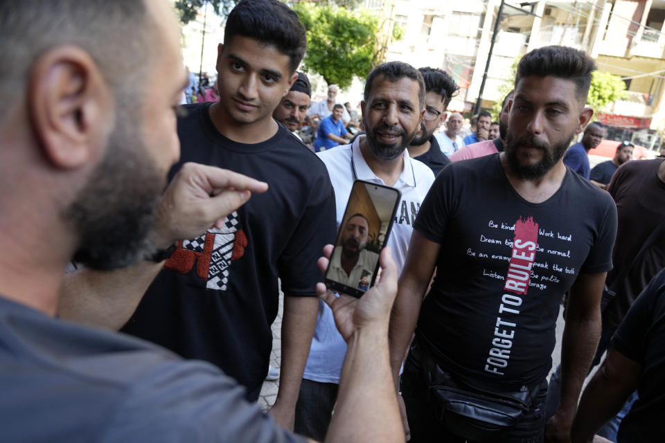 Abed Soubra, who is allegedly holding hostages in a bank in an effort to get to funds in his account, speaks through a video call to people gathering outside the bank in Beirut, Lebanon, Friday, Sept. 16, 2022. Depositors broke into at least four banks in different parts of crisis-hit Lebanon Friday demanding that they get their trapped savings as chaos spreads in the small Mediterranean nation in the middle of a historic economic meltdown. (AP Photo/Bilal Hussein)