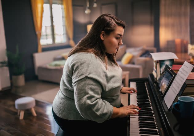"[Playing piano] exercises a different part of my brain, reduces stress, and makes me happy to fill our house with music," one reader said. <span class="copyright">zeljkosantrac via Getty Images</span>
